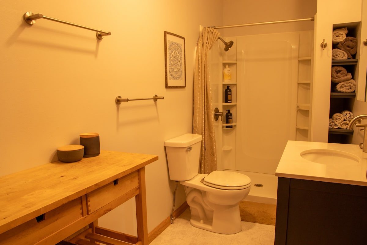 The bathroom, with walk-in shower and stacked towels