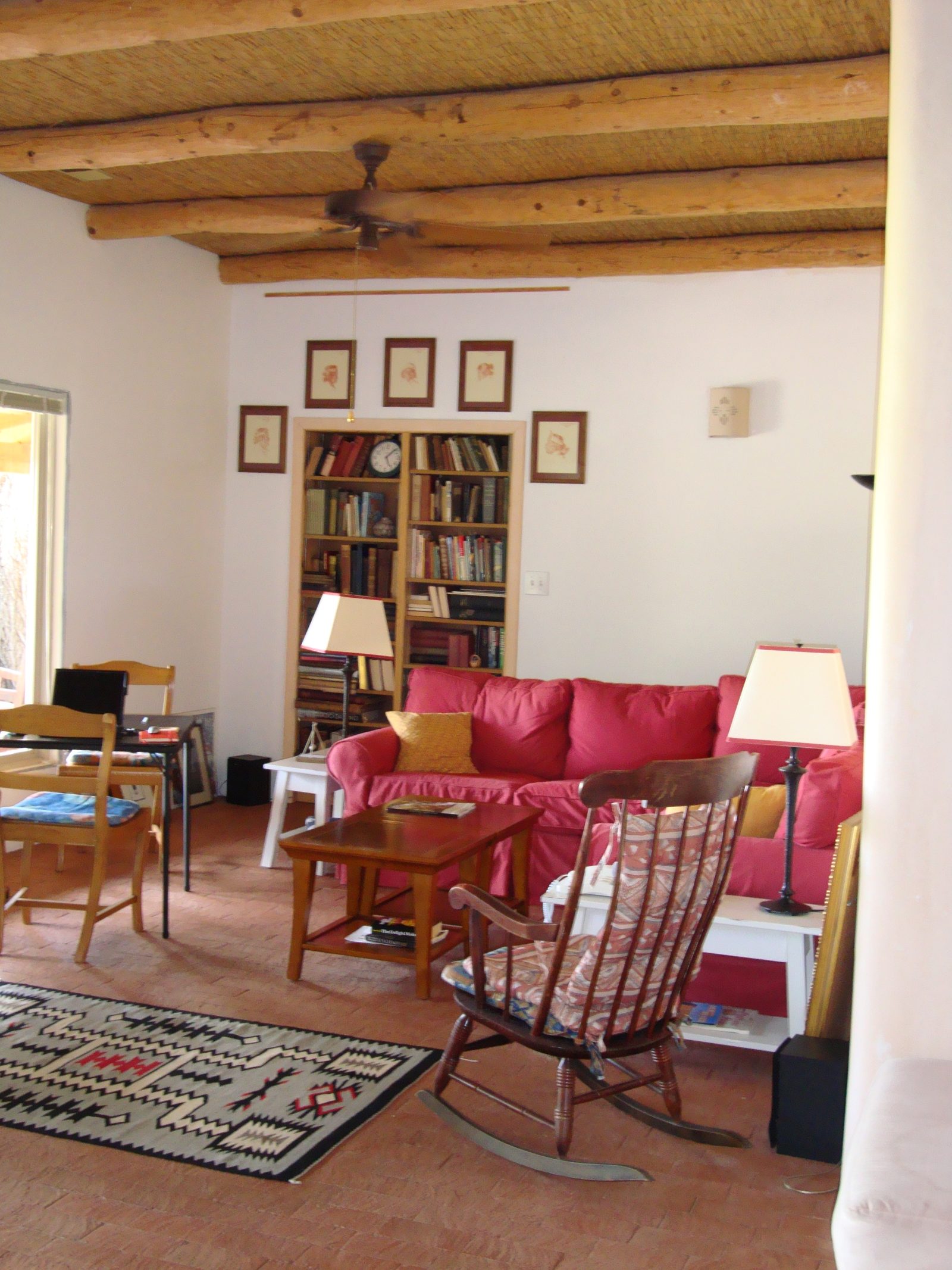 The sitting room, with Navajo rug, bookshelves and a rocking chair